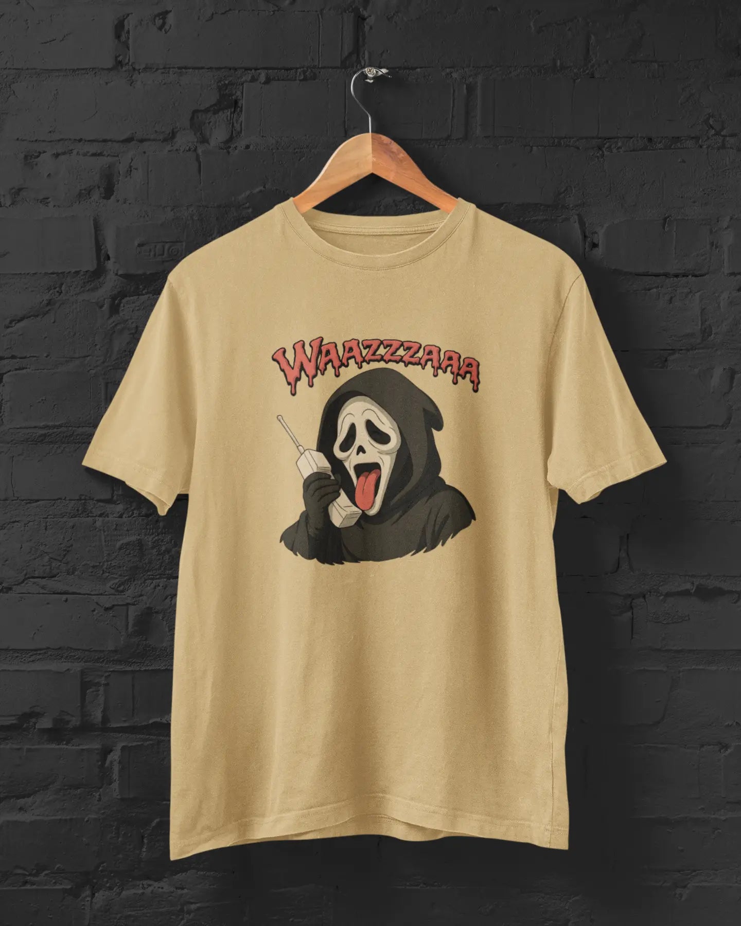 Beige t-shirt with a graphic design of a cartoonish grim reaper and 'WAZZZAAR' text on a black brick wall background.