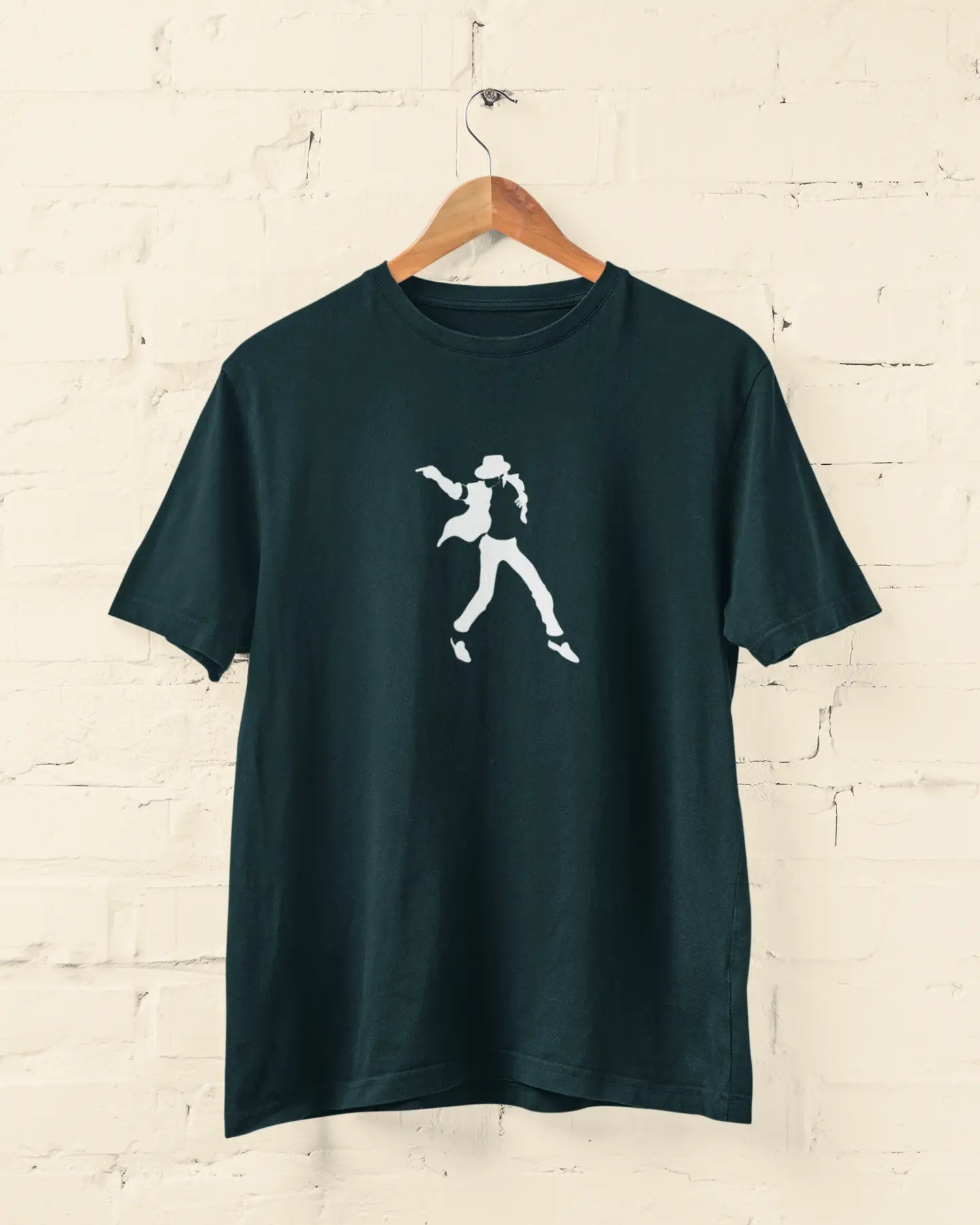 Dark michael jackson petrol blue t-shirt with a white graphic on a wooden hanger against a light brick wall.